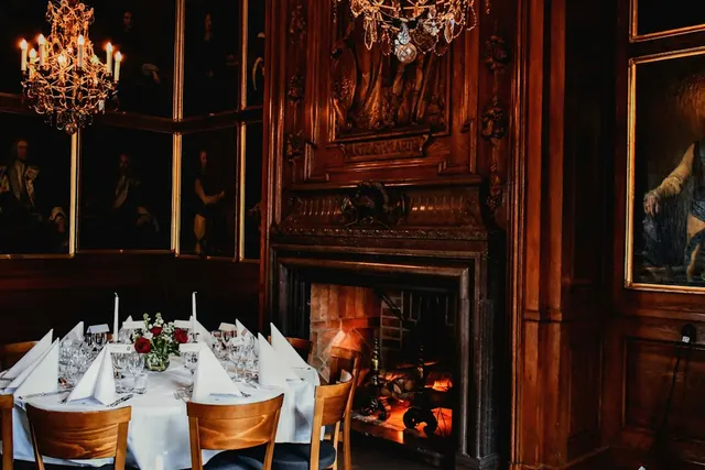 The Hearth Room: a long candlelit table beside a stone fireplace
